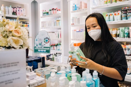 woman shopping for hand sanitizer wearing a mask