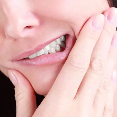 close up of a woman in pain because of canker sores in her mouth, seeking treatment from a pharmacist