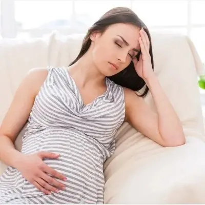 photo of a woman suffering from nausea and vomiting during pregnancy also known as morning sickness