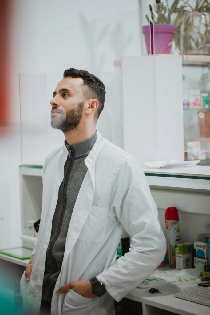photo of a pharmacists leaning casually and consulting with someone out of frame about medical cannabis