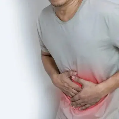 photo of a man doubled over because of discomfort from pinworms.