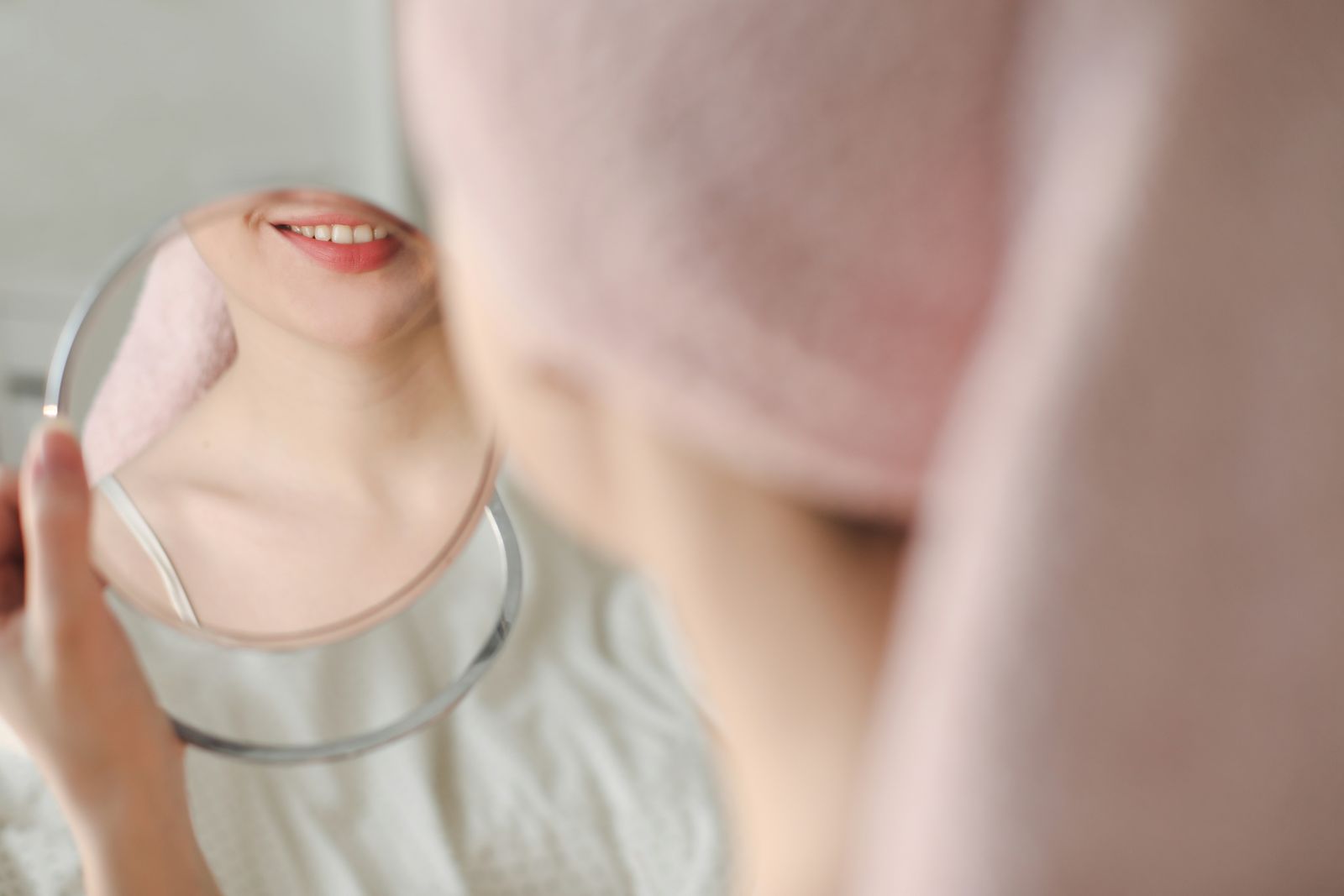 photo pf a woman looking in a mirror inspecting her acne after treatment by a centrum pharmacy pharmacist