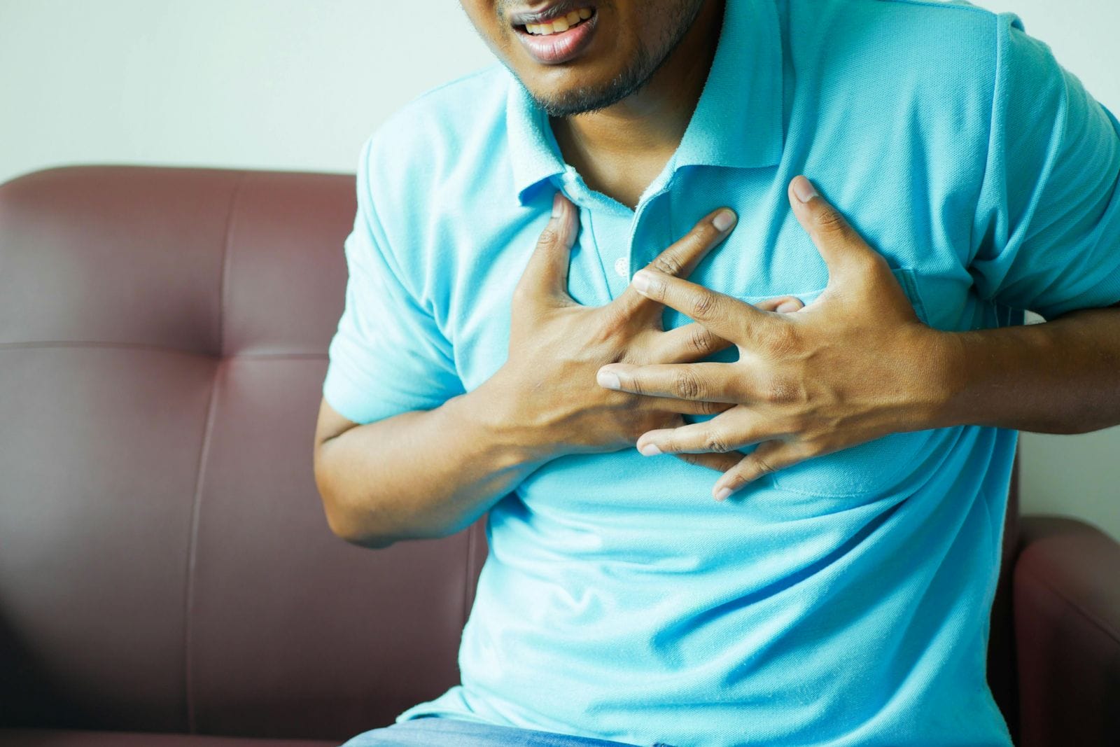 a photo of a man holding his hands to his chest representing heartburn - treatable by a centrum pharmacist in Ottawa and Orleans.